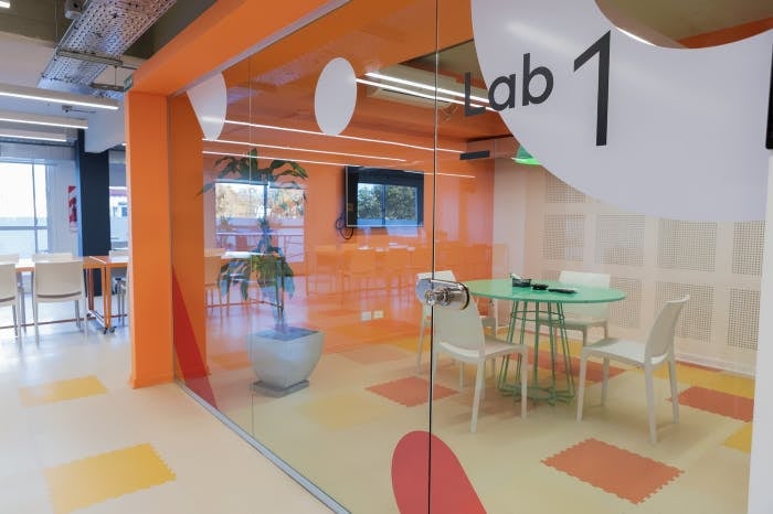 Foto de una parte de las oficinas de Aerolab donde se ve una sala con una mesa y sillas vacias